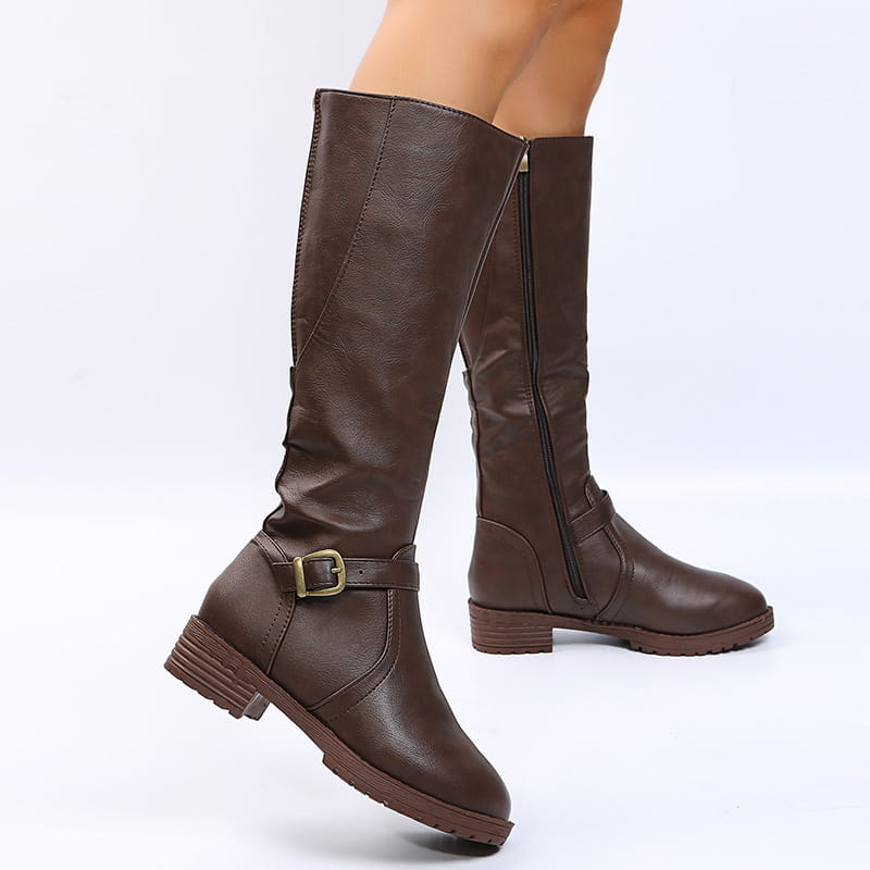 Leather knee high knight boots in brown featuring a gold toned buckle strap and zipper closure.