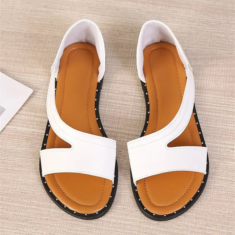 Sandalias de cuero con correas cruzadas color blanco para mujer con diseño minimalista de tiras, suelas negras con tachuelas y plantillas color cuero