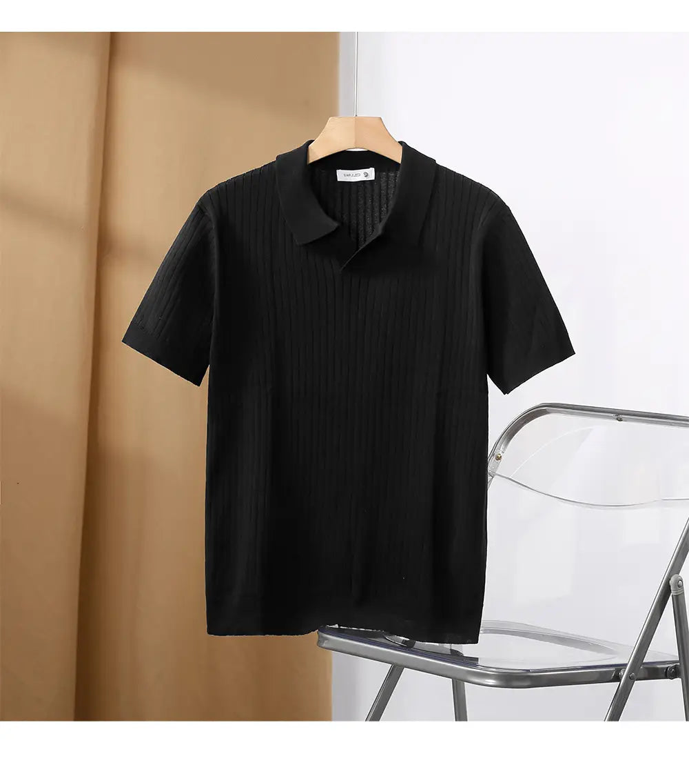 Schwarzes kurzärmeliges gestreiftes Jacquard-Strick-Poloshirt mit gerippter Textur und abstehendem Kragen, auf einem Holzbügel hängend.