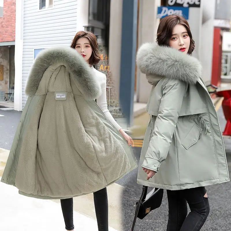 Hellgrüner Damen-Winter-Parka in mittlerer Länge mit einer plüschigen grauen Kunstfellkapuze und einem gesteppten Design.