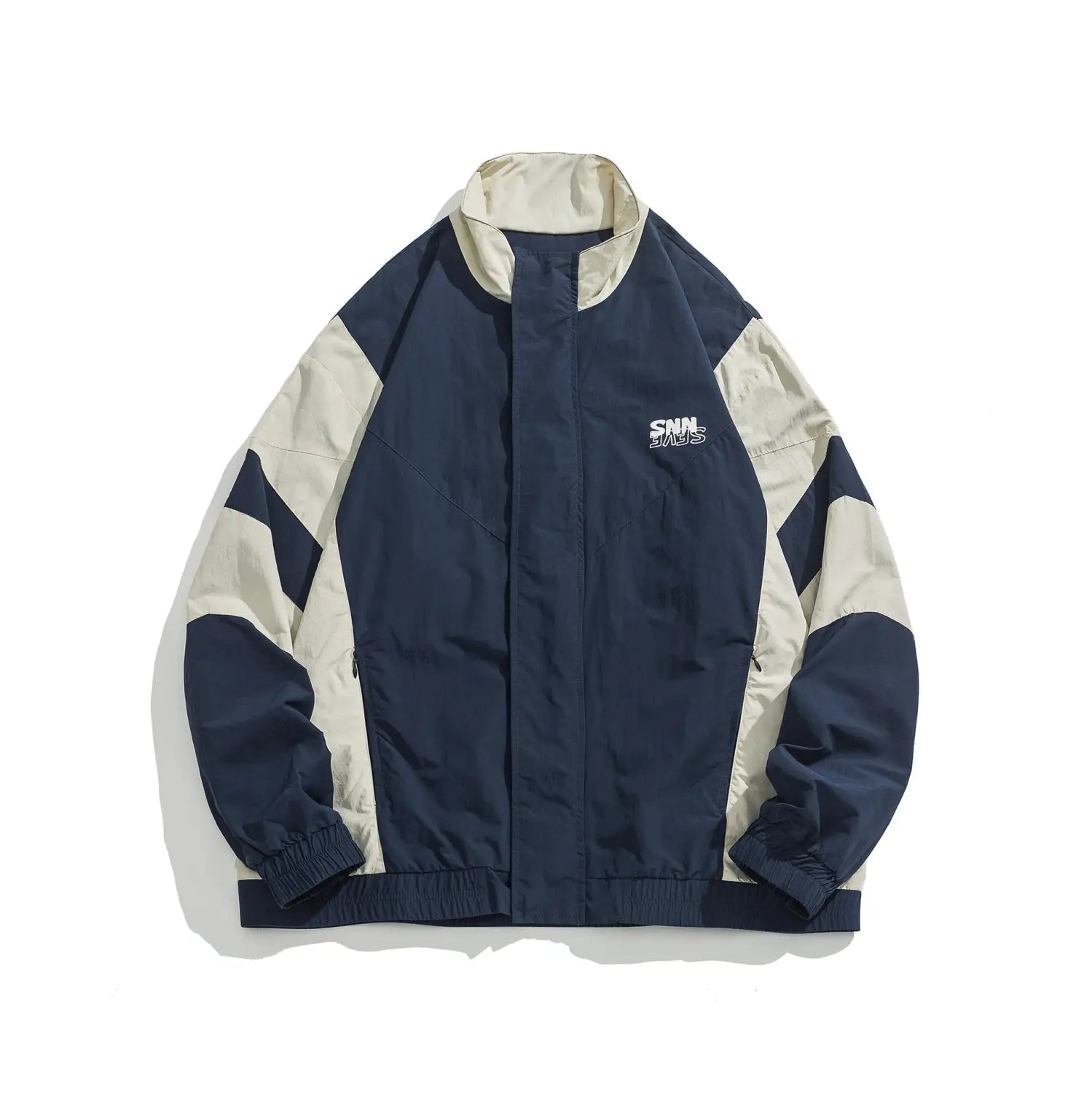 Veste coupe-vent ample à blocs de couleurs bleu marine et crème, avec un logo brodé discret sur la poitrine, conçue pour des vêtements d’extérieur légers.