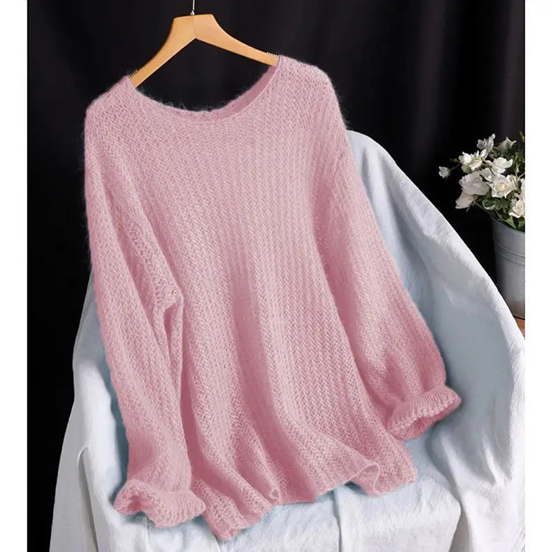 ein staubiges rosafarbenes Pulloveroberteil in offener Strickoptik, als Blusenstil gestricktes Oberteil, mit einer weichen, lockeren Passform und gerippten Bündchen, das auf einem Holzkleiderbügel hängt