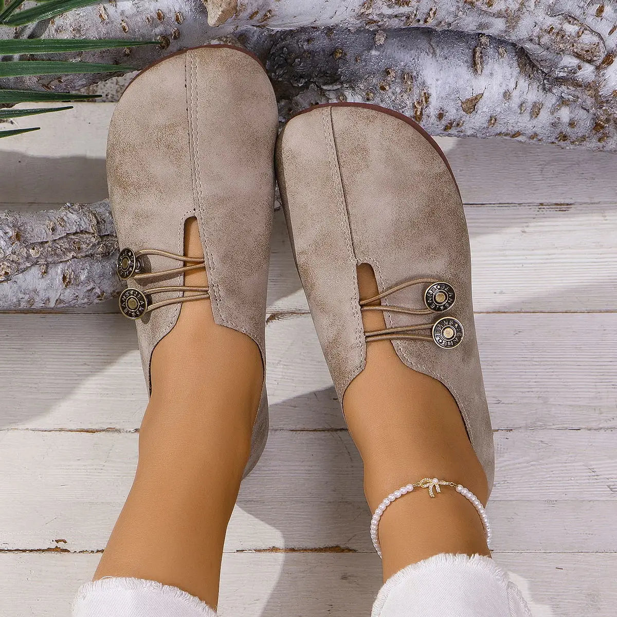 Beige suede slip-on women’s loafers with square toe lace-up design, decorative metal buttons, and elastic straps in leather and suede.