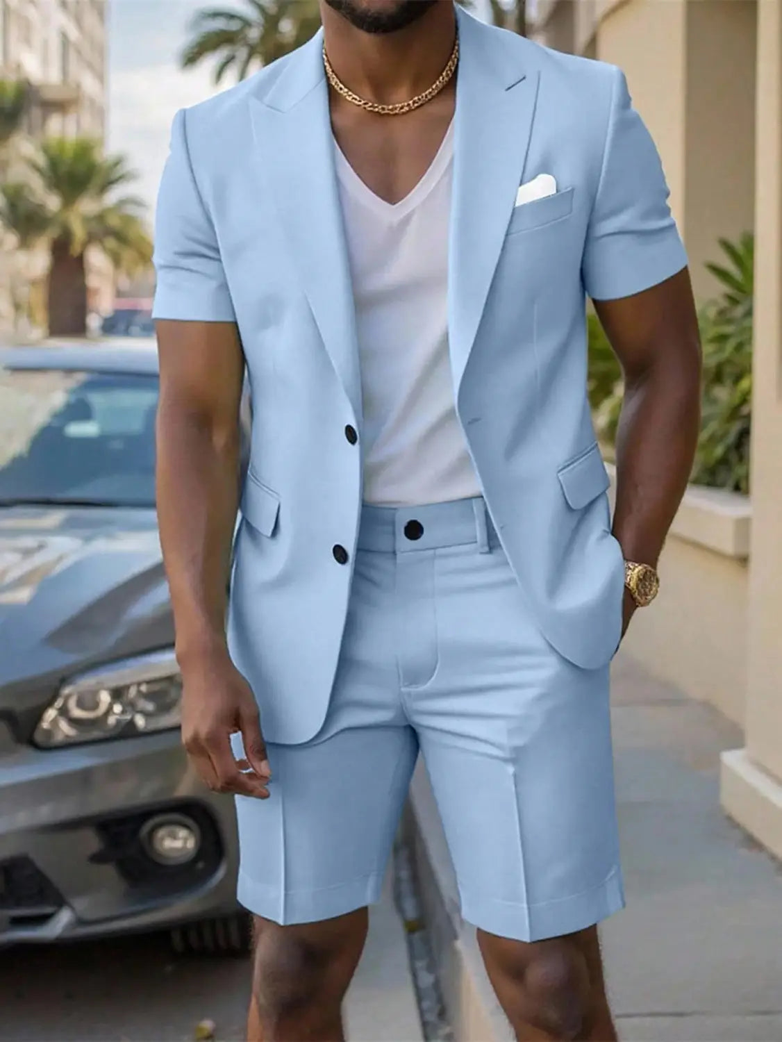 Light blue short sleeve suit and shorts set featuring black buttons and a white pocket square designed for formal summer occasions.