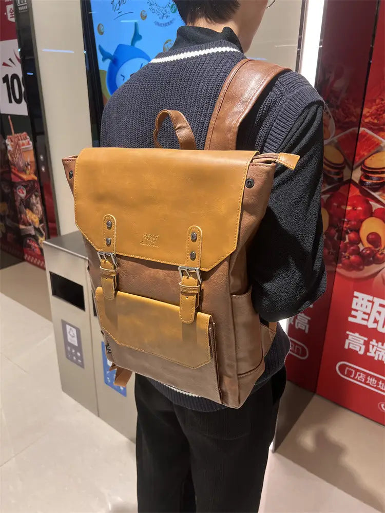 Tan leather vintage college backpack with brown accents and metal buckles designed for large capacity travel use