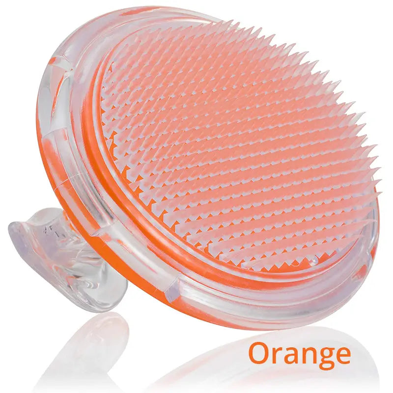 Transparent orange silicone scalp massage brush with a curved oval-shaped head and soft bristles for exfoliating and stimulating hair meridian.