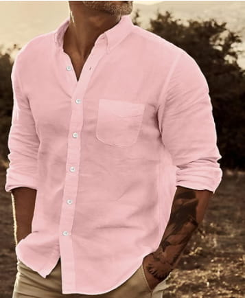 A soft pink men’s slim fit cotton long sleeve button down shirt with a chest pocket and rolled-up sleeves.