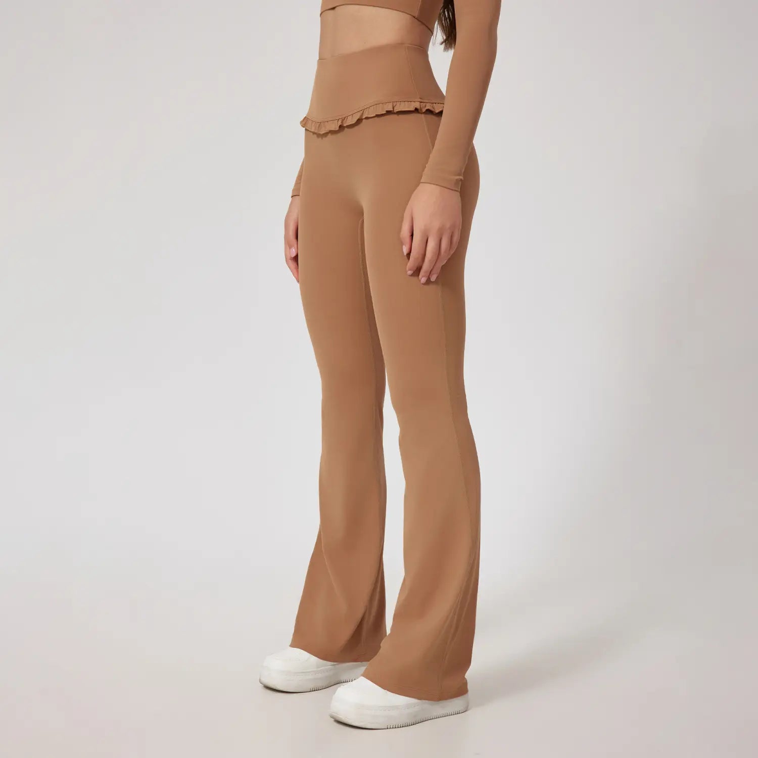 Leggings évasés beiges taille haute avec un détail de bas à volants, idéal pour la tenue active.