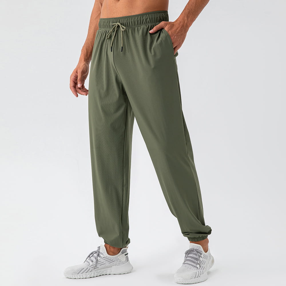 Men’s olive green quick dry nylon loose fit athletic track pants with drawstring waist elastic cuffs and side pockets.