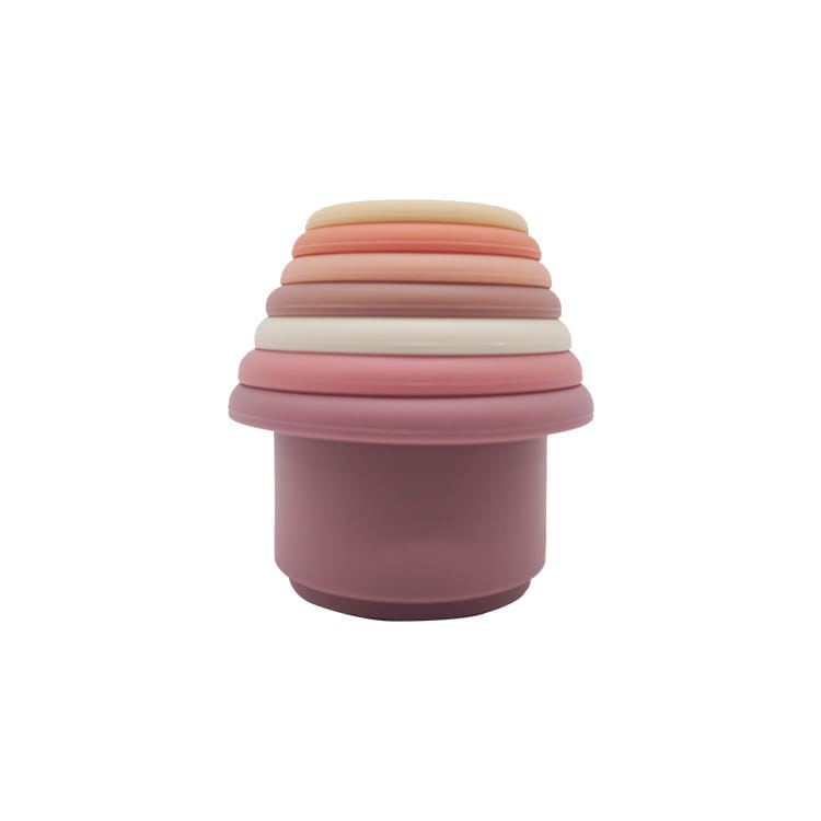 A stack of pastel-colored silicone stacking cups in soft pink peach and cream hues designed as an educational nesting baby toy.