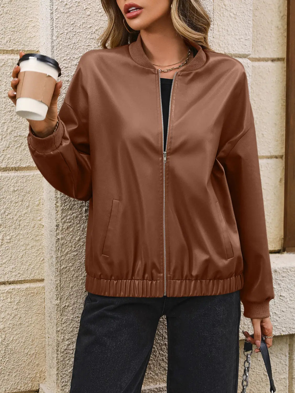 Brown faux leather bomber jacket with front zipper and ribbed elastic cuffs for a stylish and comfortable fit