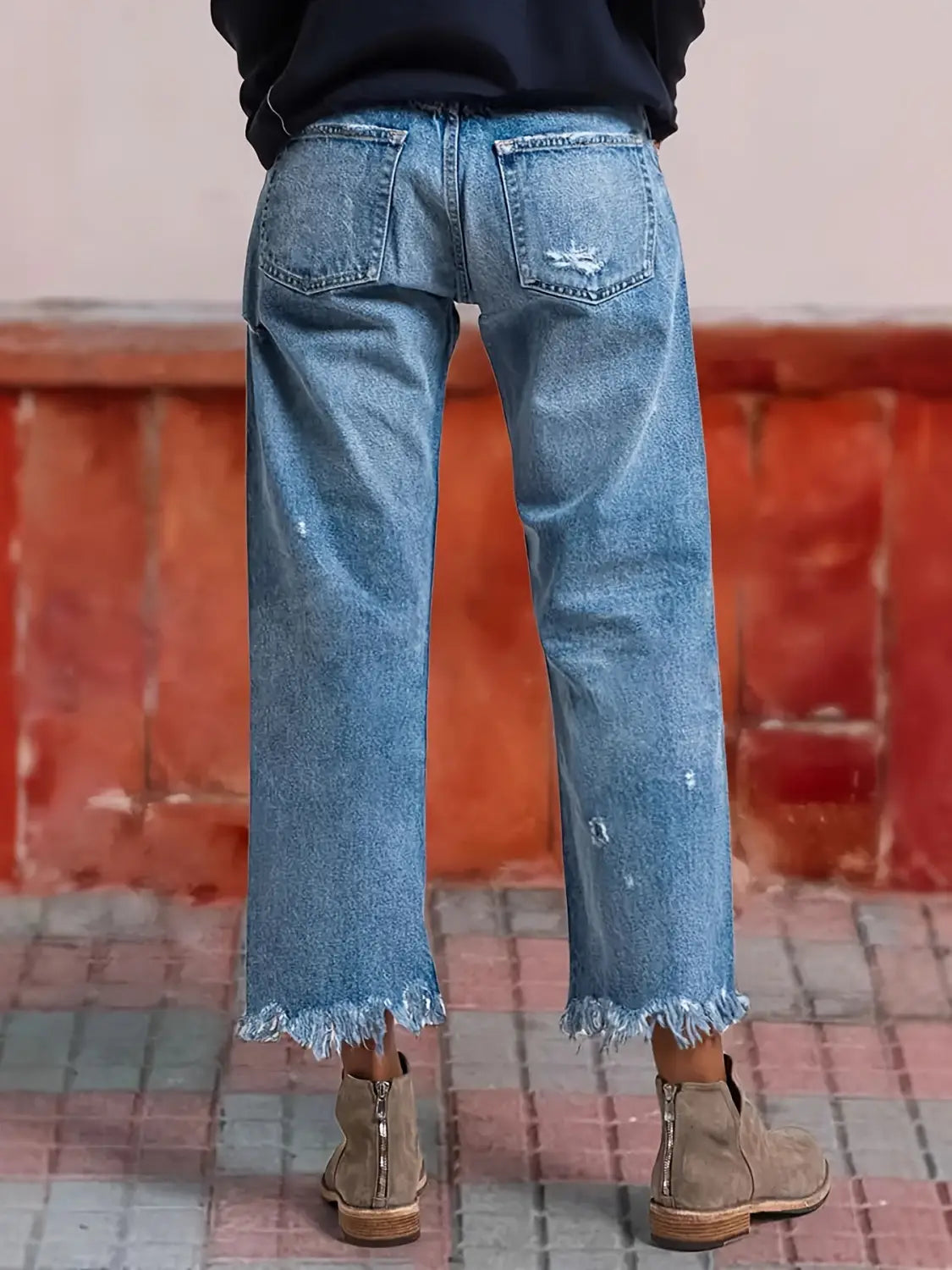 Jeans droits gris délavé déchirés confectionnés dans un denim à lavage clair, avec ourlets effilochés et aspect vieilli subtil.