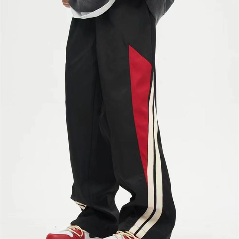 Men’s retro striped athletic track pants in black with bold red and white side stripes designed for sports and casual wear.