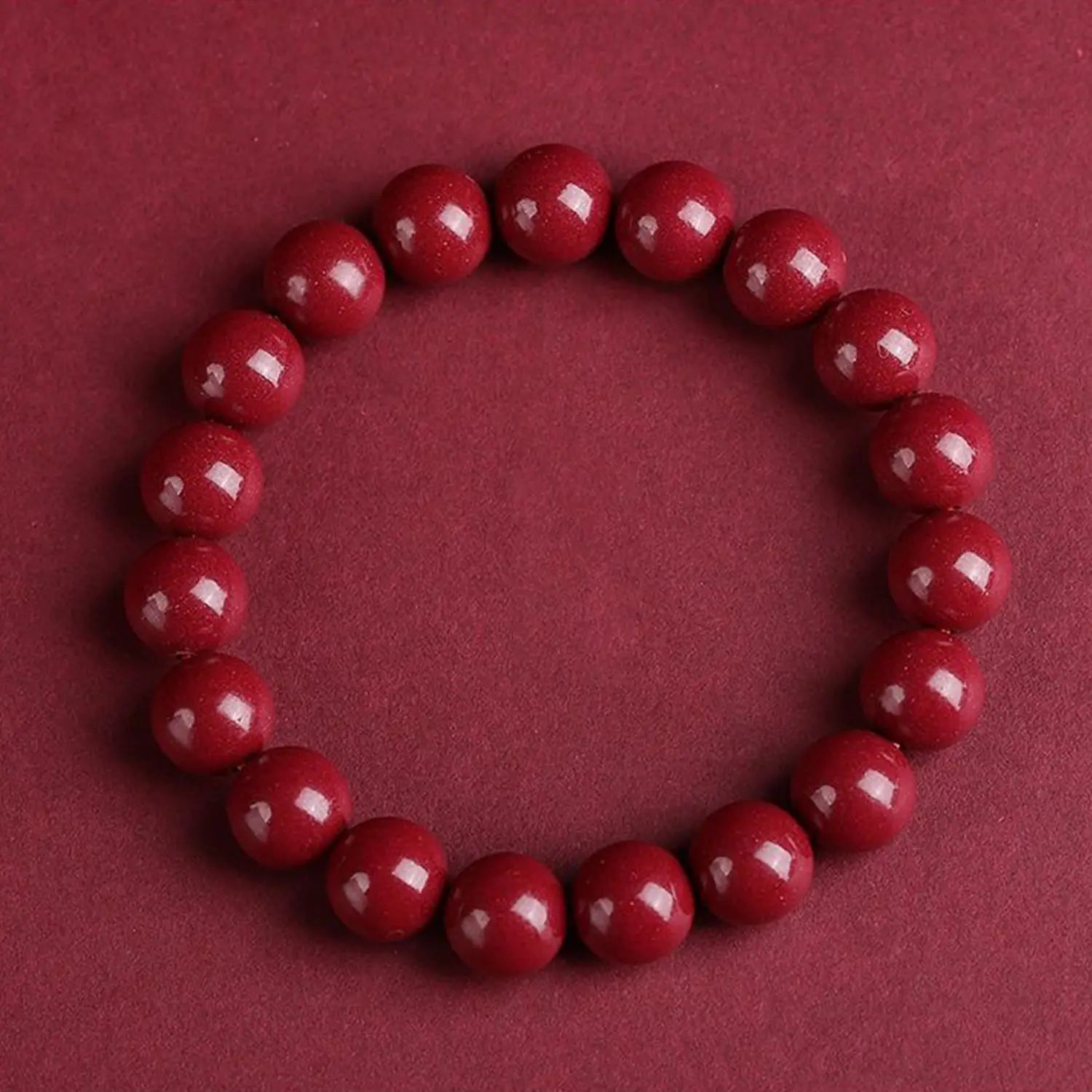 A polished red cinnabar spherical bead bracelet featuring smooth glossy uniformly sized beads.