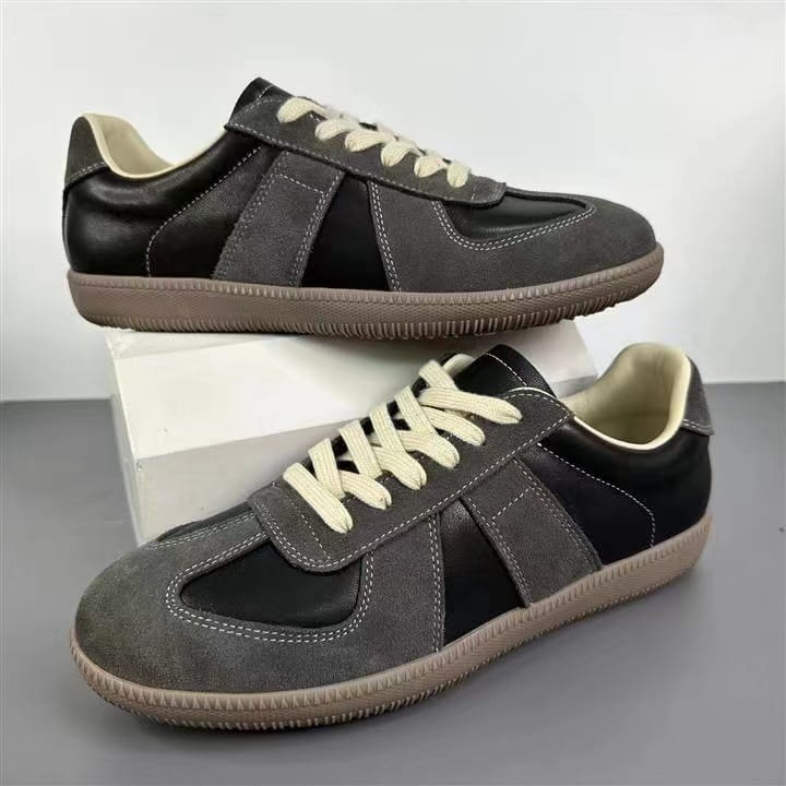 Ledersneaker, vielseitige Freizeitschuhe im Low-Top-Design, in Schwarz und grauem Veloursleder mit cremefarbenen Schnürsenkeln.