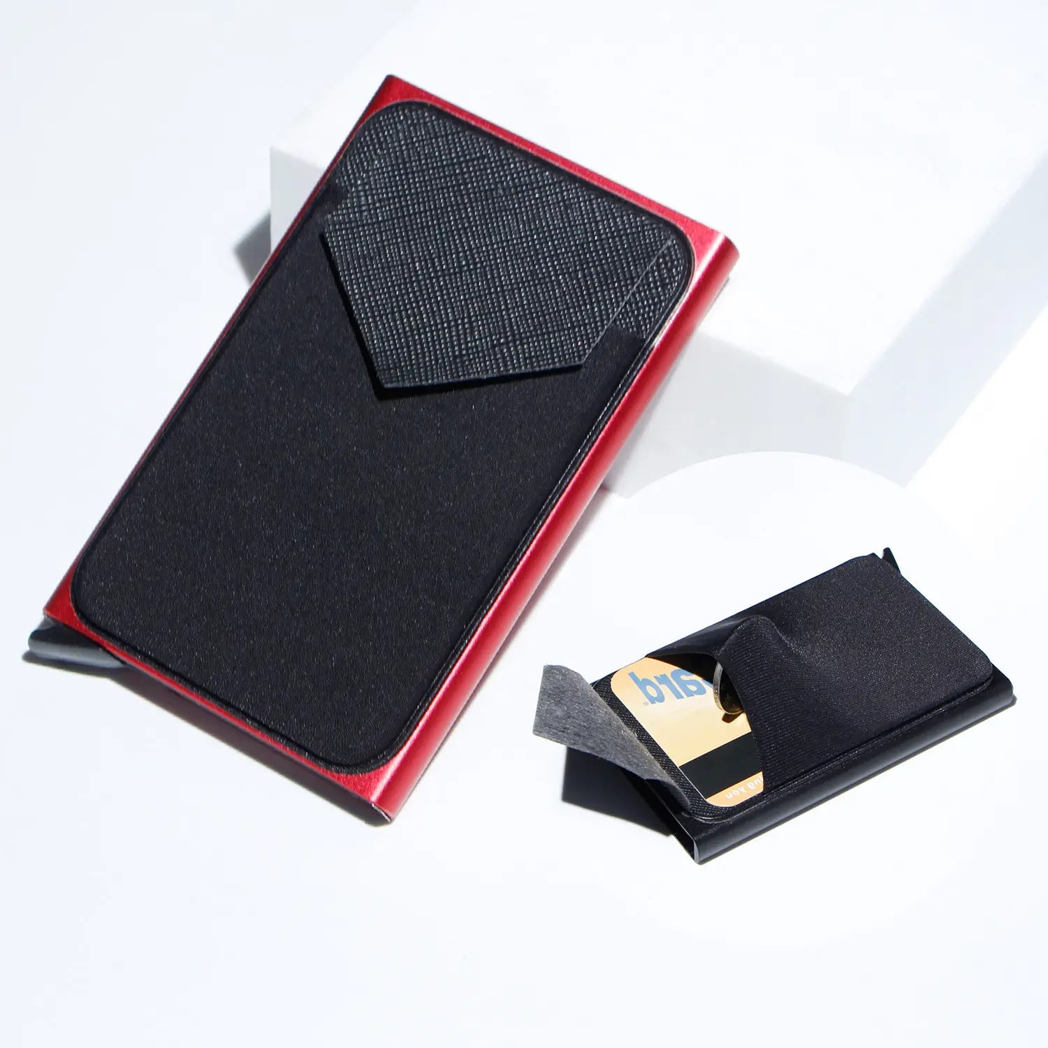 Minimalist RFID blocking aluminum multi card wallet in red and black metal with a textured fabric pocket.