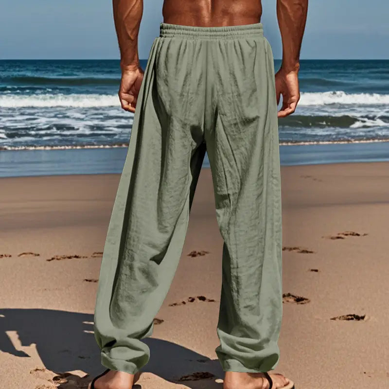 Men’s olive green loose-fitting linen joggers with an elastic waistband and tapered legs designed as casual drawstring pants.