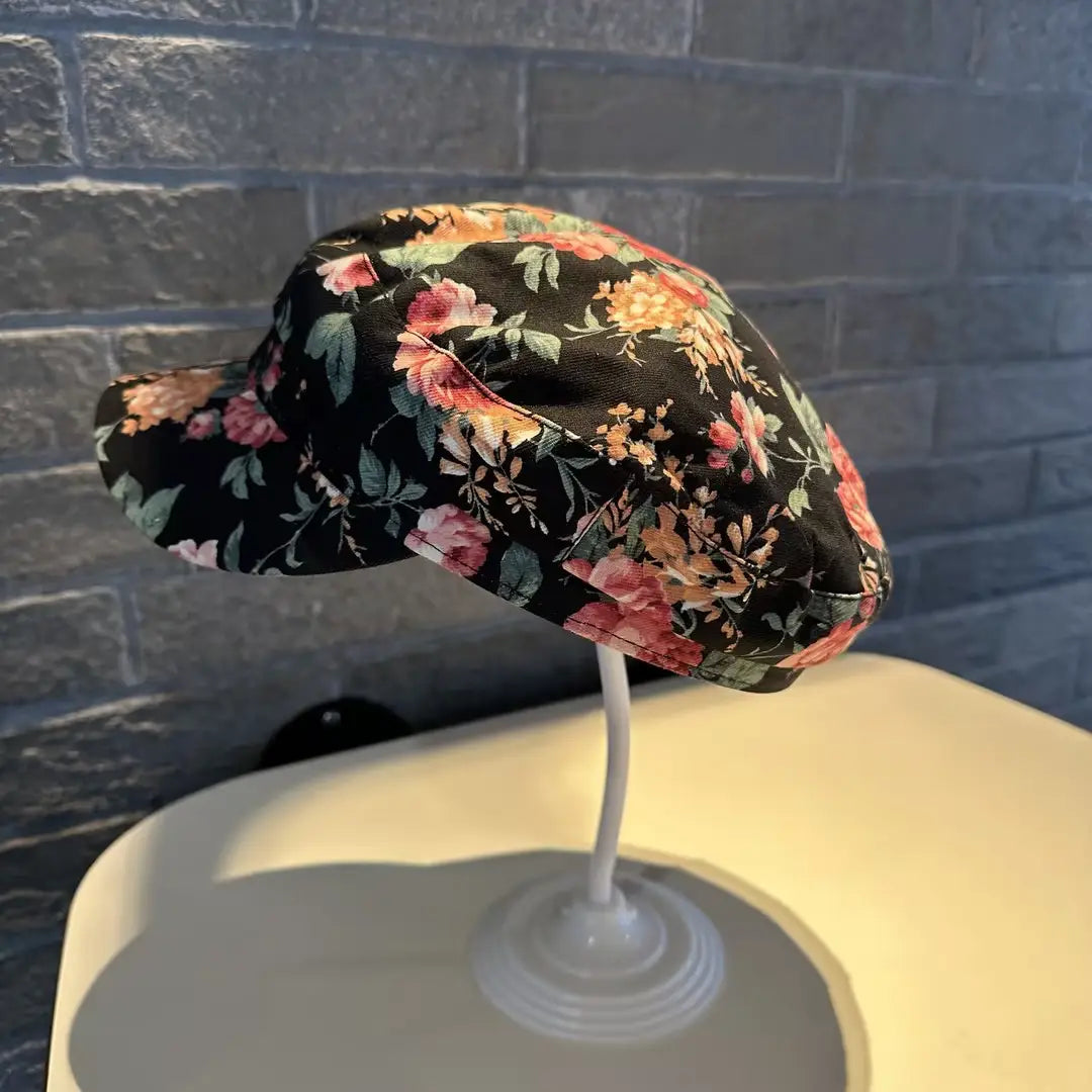 Gorra tipo bucket hat floral negra con patrón, estilo coreano, impresa, con flores en rosa, naranja y amarillo sobre una tela oscura.