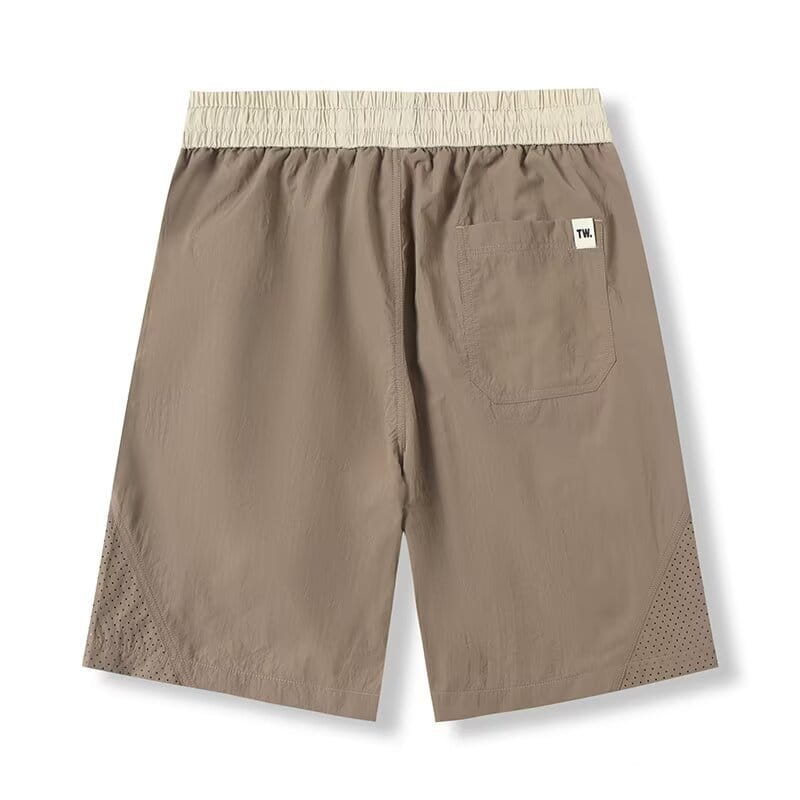 Shorts en nylon décontractés pour hommes, coupe droite, beiges, avec une ceinture élastique beige, des panneaux latéraux perforés et une petite étiquette blanche sur la poche arrière, visible depuis l’arrière.