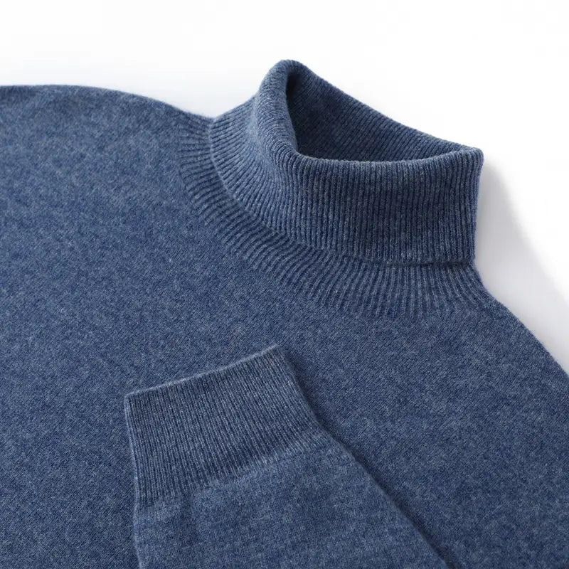 Un pull col roulé en cachemire bleu marine chiné pour homme, doux, avec un col et des poignets en maille côtelée, conçu comme un pull ample.