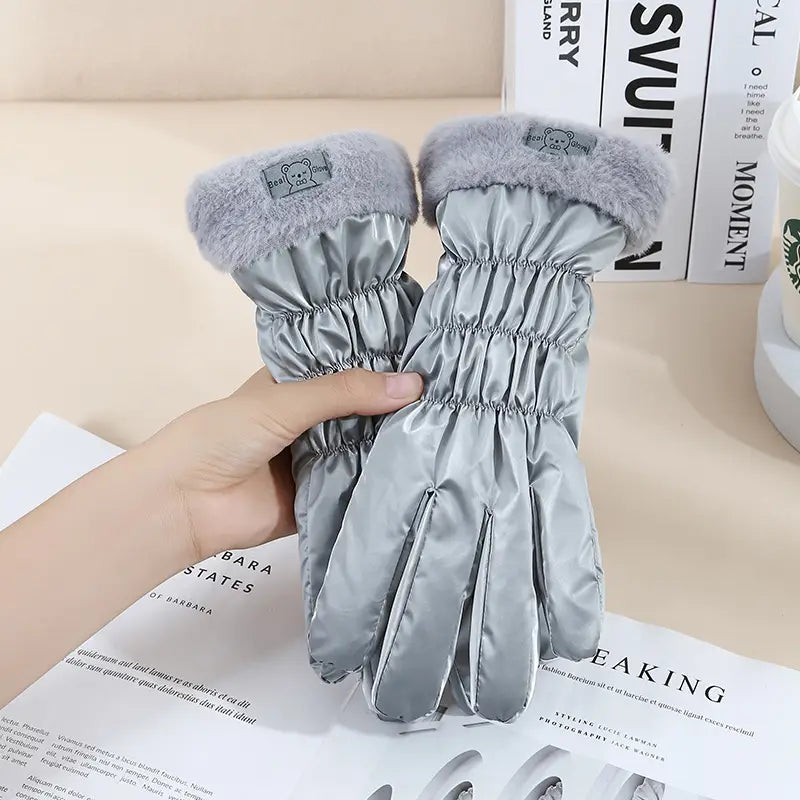 Silver satin women touch screen winter fleece gloves with plush gray faux fur cuffs and a small embroidered bear patch on the wrist.