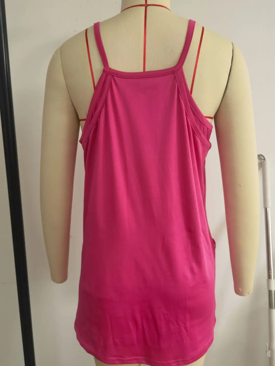 A vibrant pink spaghetti strap top made of soft fabric is displayed on a mannequin as part of a women casual romper and strap top set.