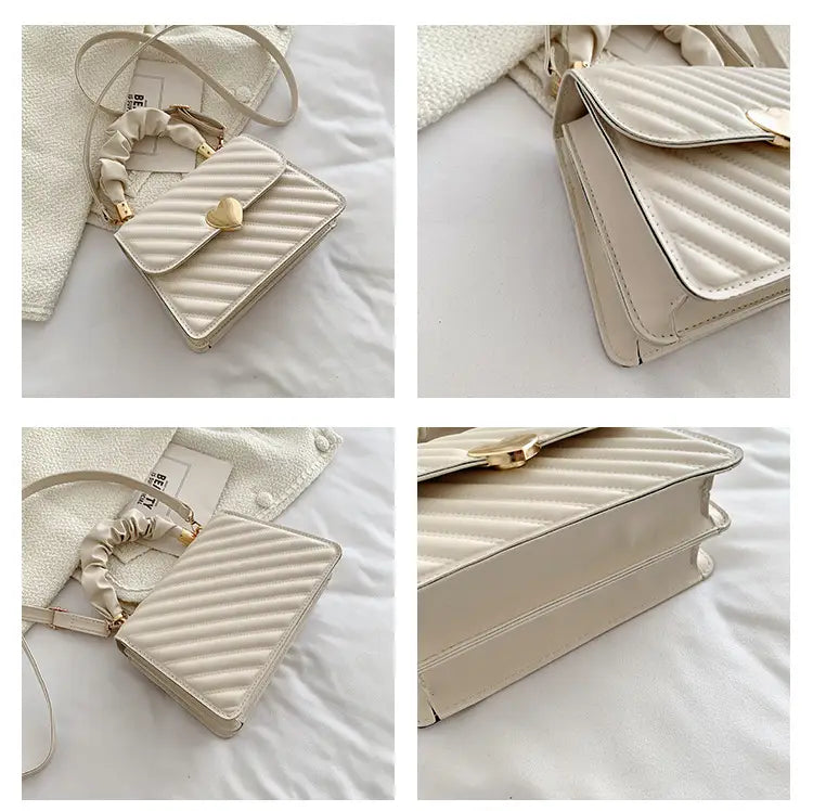 Cream-colored quilted crossbody bag with gold-tone heart-shaped clasp and elasticated ruched handle.