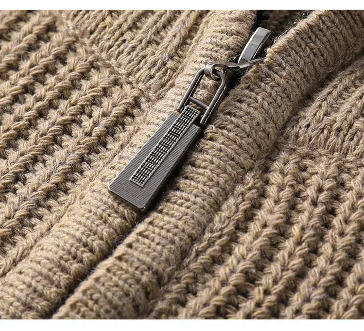 Der Zipper-Zug am beigen gestrickten Herren-Halbrollkragenrippstrickpullover weist eine elegante dunkelmetallische Ausführung mit einem erhabenen Rastermuster auf.