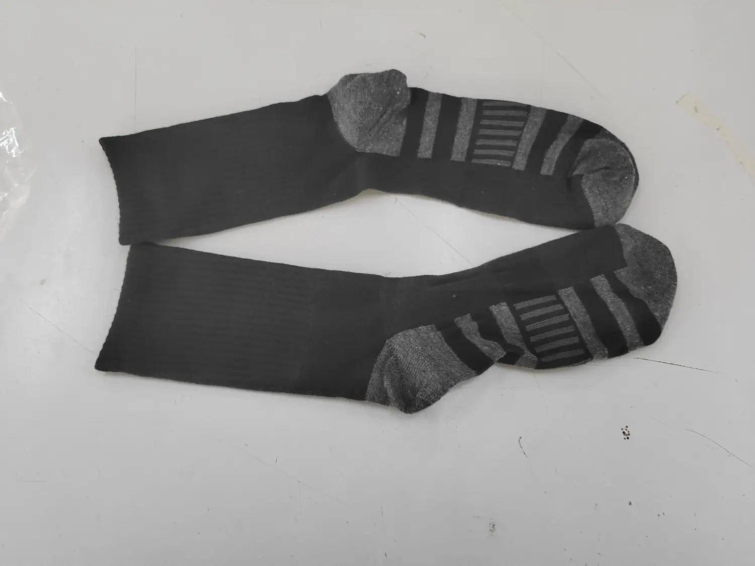 chaussettes de sport épaisses pour grandes tailles (plus size) noires en coton, en tissu respirant, avec semelles renforcées en gris et motifs rayés sur la plante du pied.