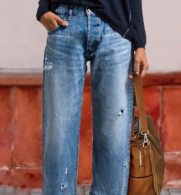 Jeans droits gris délavé déchirés confectionnés dans un denim bleu clair, avec taille haute et détails de détérioration intentionnels.