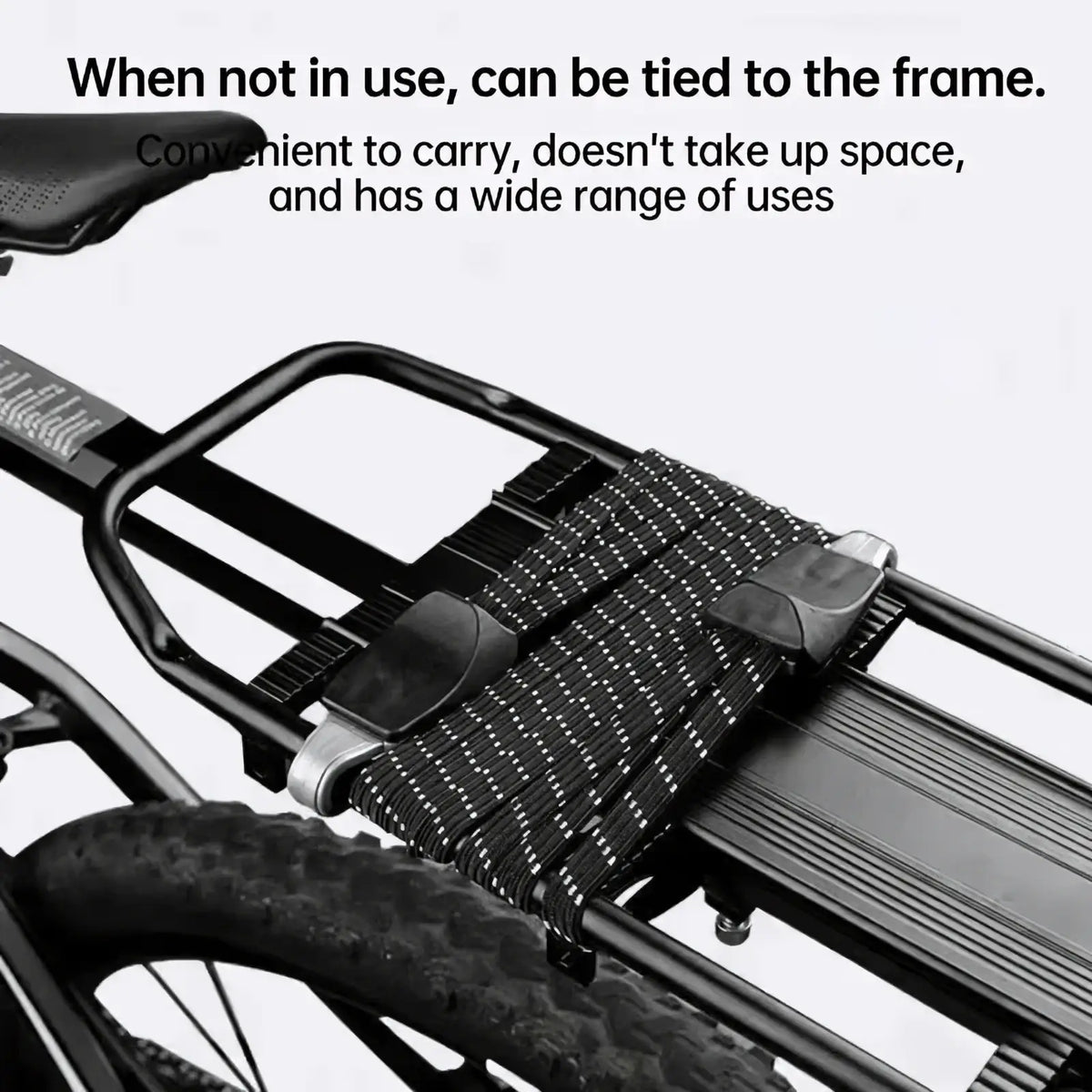 Black elastic bicycle cargo strap with reflective white dots and black plastic buckles secured on a bicycle rack