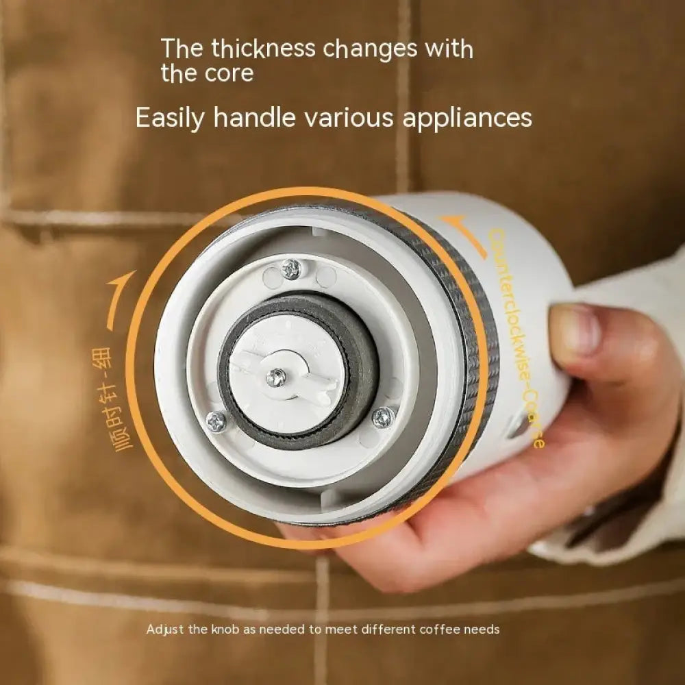 Compact automatic electric coffee grinder in white and gray with adjustable textured grip and metallic band with orange accent