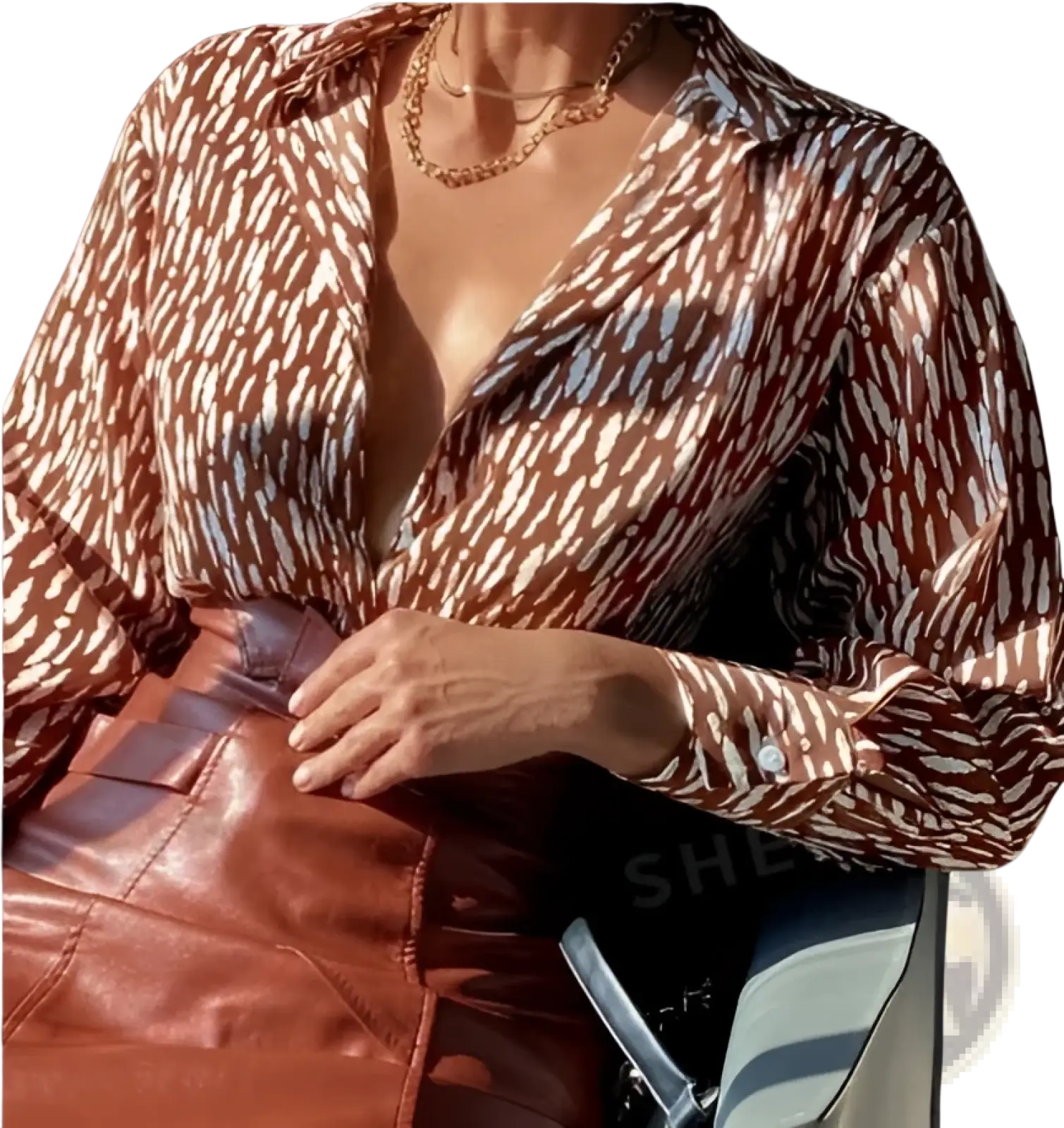 A brown and white patterned satin blouse with a deep v-neckline perfect for elegant occasions