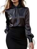 Black satin blouse with a high neck and tied bow at the collar featuring elegant puff sleeves