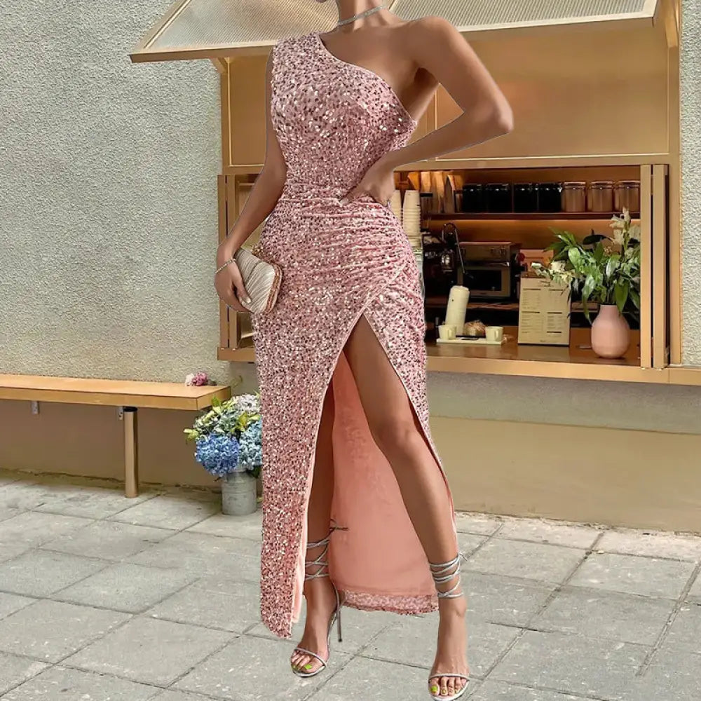 A shimmering rose gold sequined one shoulder maxi dress with a high slit and ruched detailing