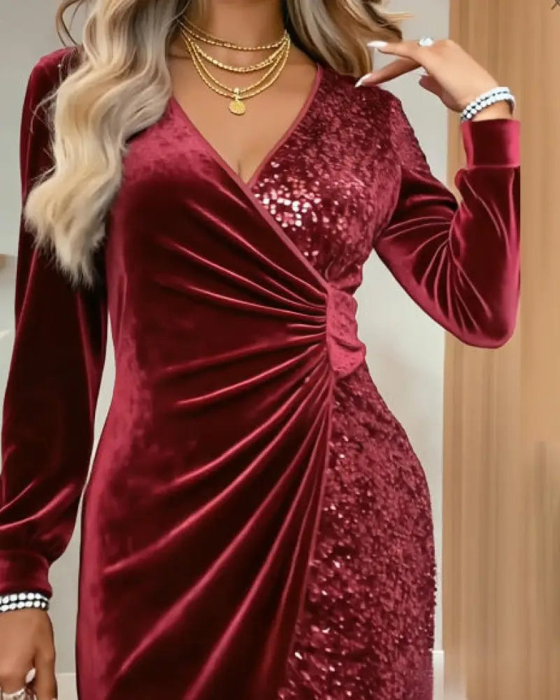 A deep red velvet v neck long sleeve wrap dress with a sequined panel on the right side