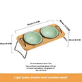 Elevated ceramic cat bowl wooden stand with light green ceramic bowls and black rims on a wooden base