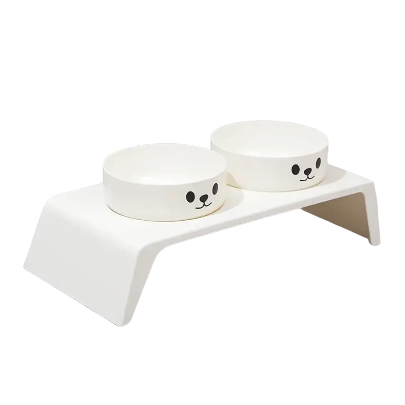 Elevated white cat-faced pet feeder with stainless steel bowls featuring simple black cartoon faces for feeding pets