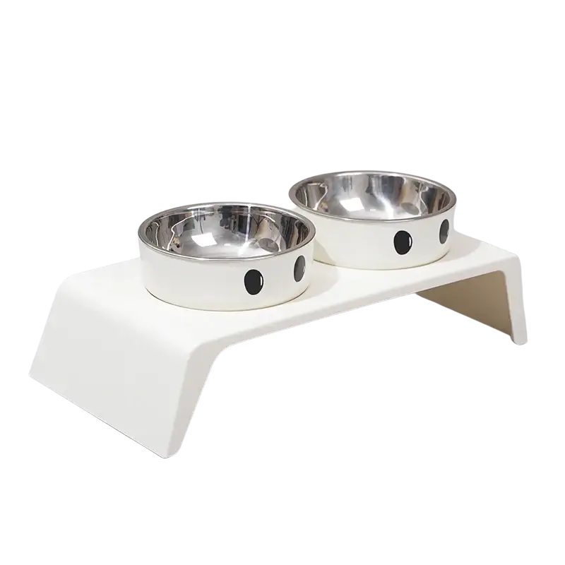 Elevated white dog feeder with raised stand and two stainless steel bowls featuring black circular eye designs