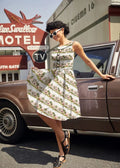 A woman wears an Elizabeth dress sleeveless knee-length in woodland sunset cotton print with stylized birds and foliage