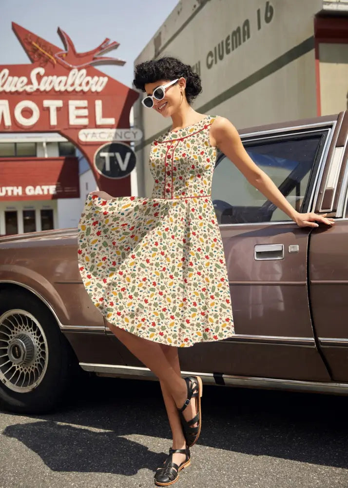 A woman wearing an Elizabeth Woodlands vintage cotton floral dress with pockets in cream and colorful flowers