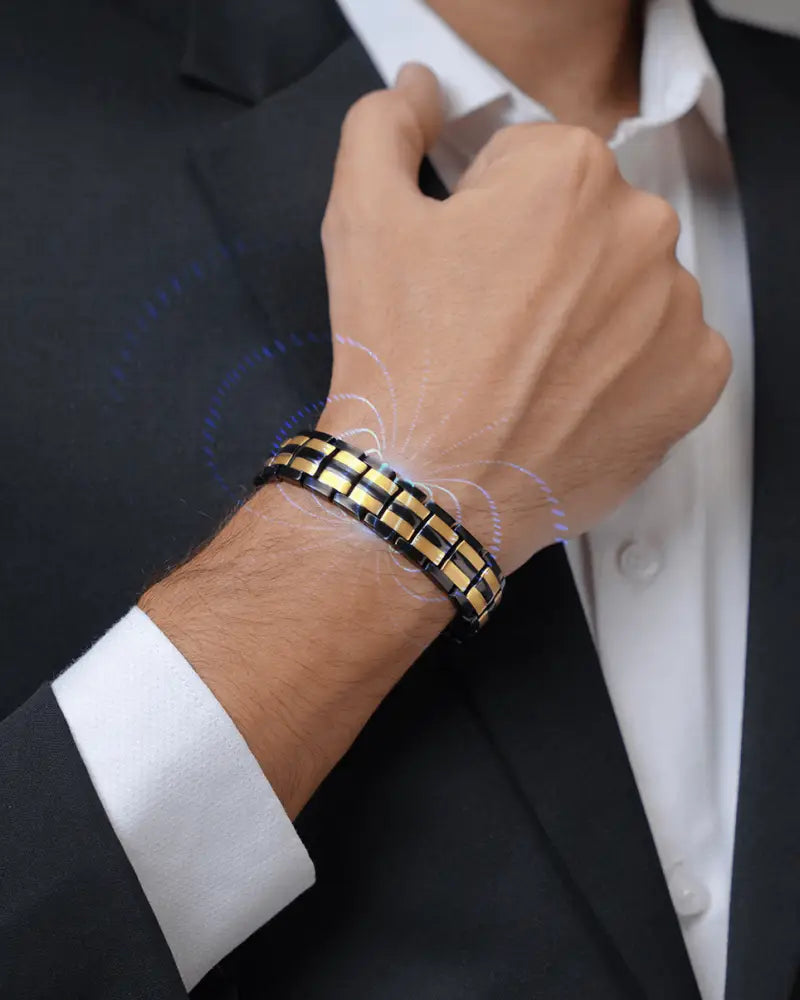 A sleek black and gold segmented titanium elliptical 5000 gauss magnetic bracelet worn on a man’s wrist