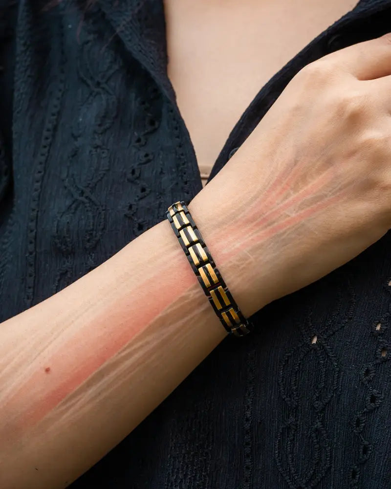 A sleek black and gold segmented magnetic bracelet worn on a wrist from ellipsemax collection