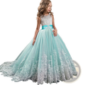 A young girl wears an embellished lace tulle flower girl princess gown in mint green and white with satin sash