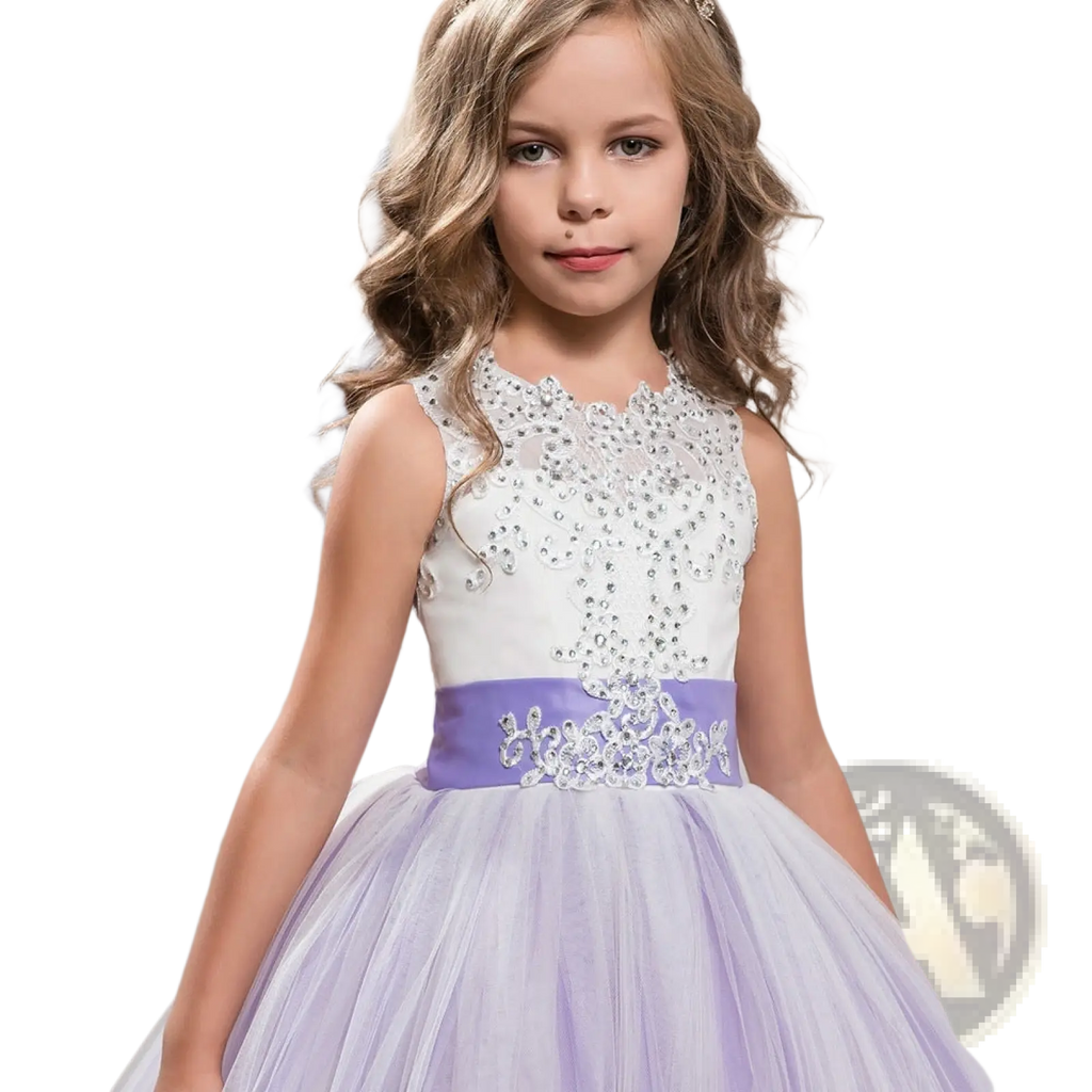 A young girl wears an embellished lace tulle flower girl princess gown in lavender with crystal-encrusted sash