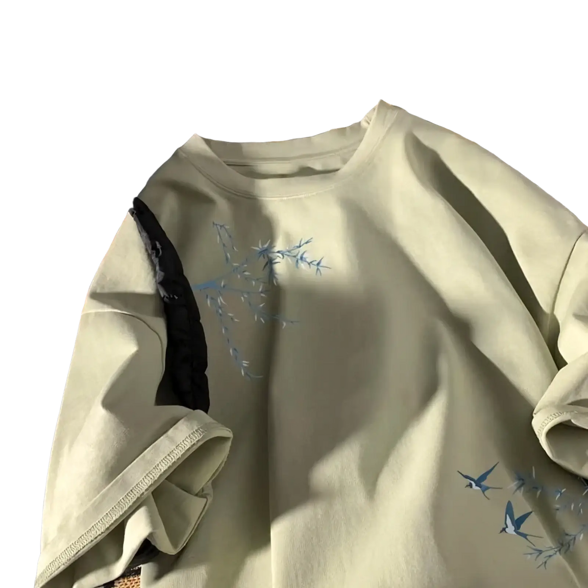 A soft mint green oversized cotton sweatshirt with delicate blue embroidered branches and birds