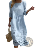 A light blue embroidered blue linen floral scalloped umbrella dress with delicate white floral embroidery and flowing fabric