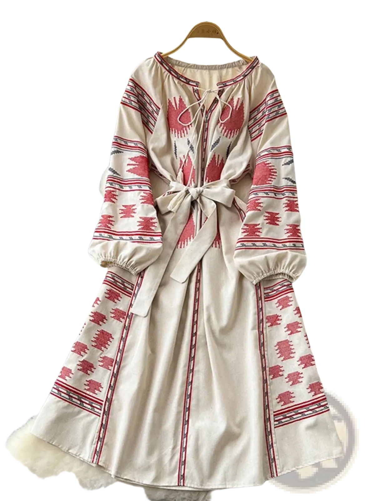 A cream-colored embroidered boho midi dress with intricate red embroidery and a tied waistband in beige