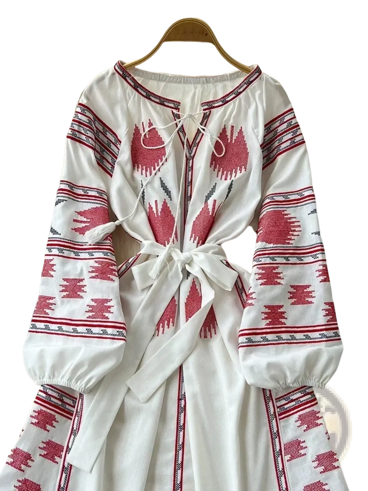 Beige embroidered boho midi dress with red and black geometric patterns, long sleeves, and a tied waistband