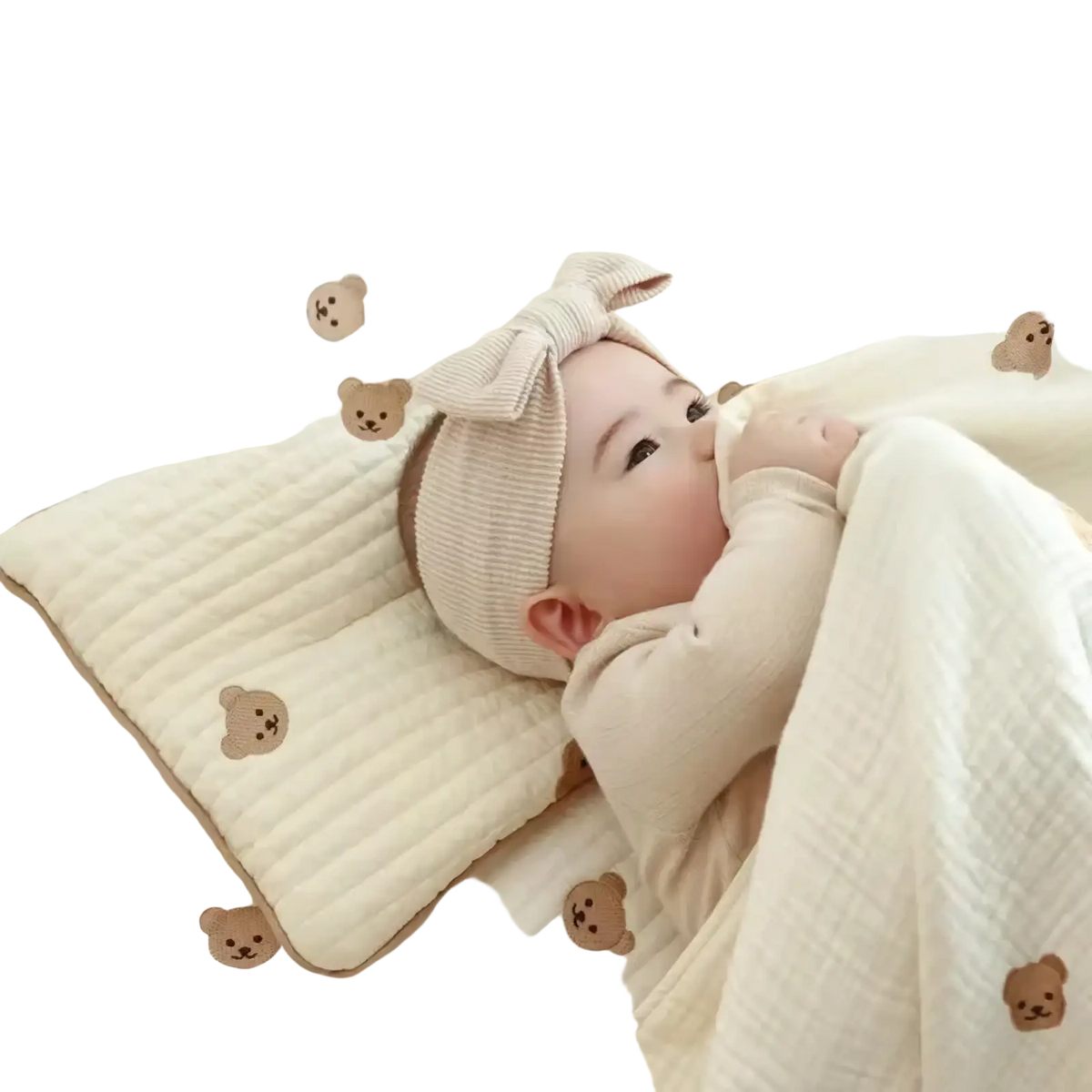 Soft cream-colored ribbed cotton headband with large bow paired with embroidered cotton baby pillow